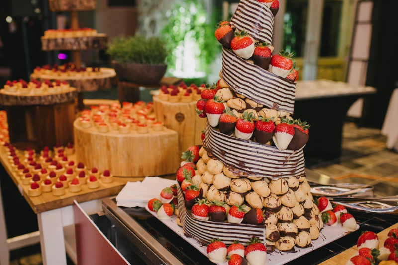 Food displays of desserts, some made of strawberries covered in chocolate.