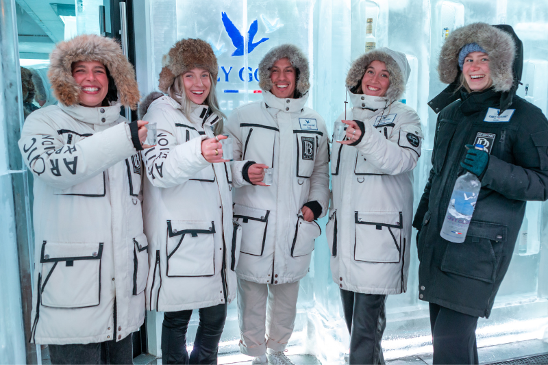 Group of friends wearing arctic parkas in a Grey Goose vodka ice room at the Bearfoot Bistro in Whistler