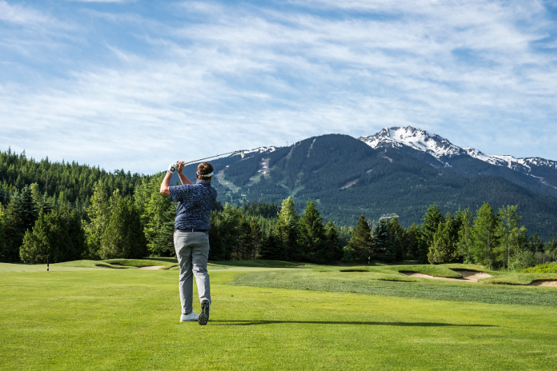 man hitting a golf ball on the Nicklaus North Golf Course, nearby to Whiski Jack Resorts Whistler