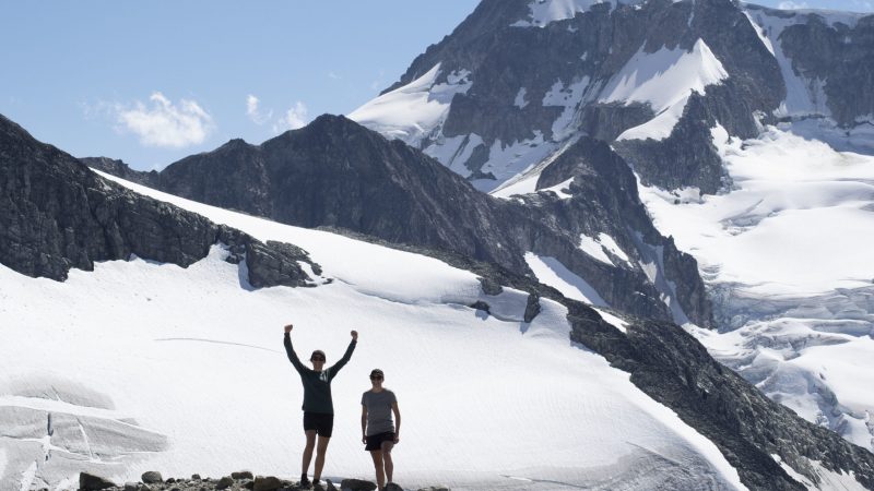 Two women hiking in summer on snowy mountains in Whistler